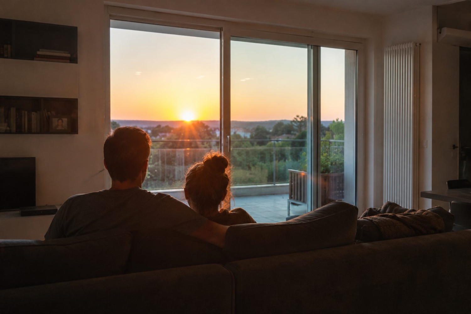 persone che guardano tramonto dalla finestra